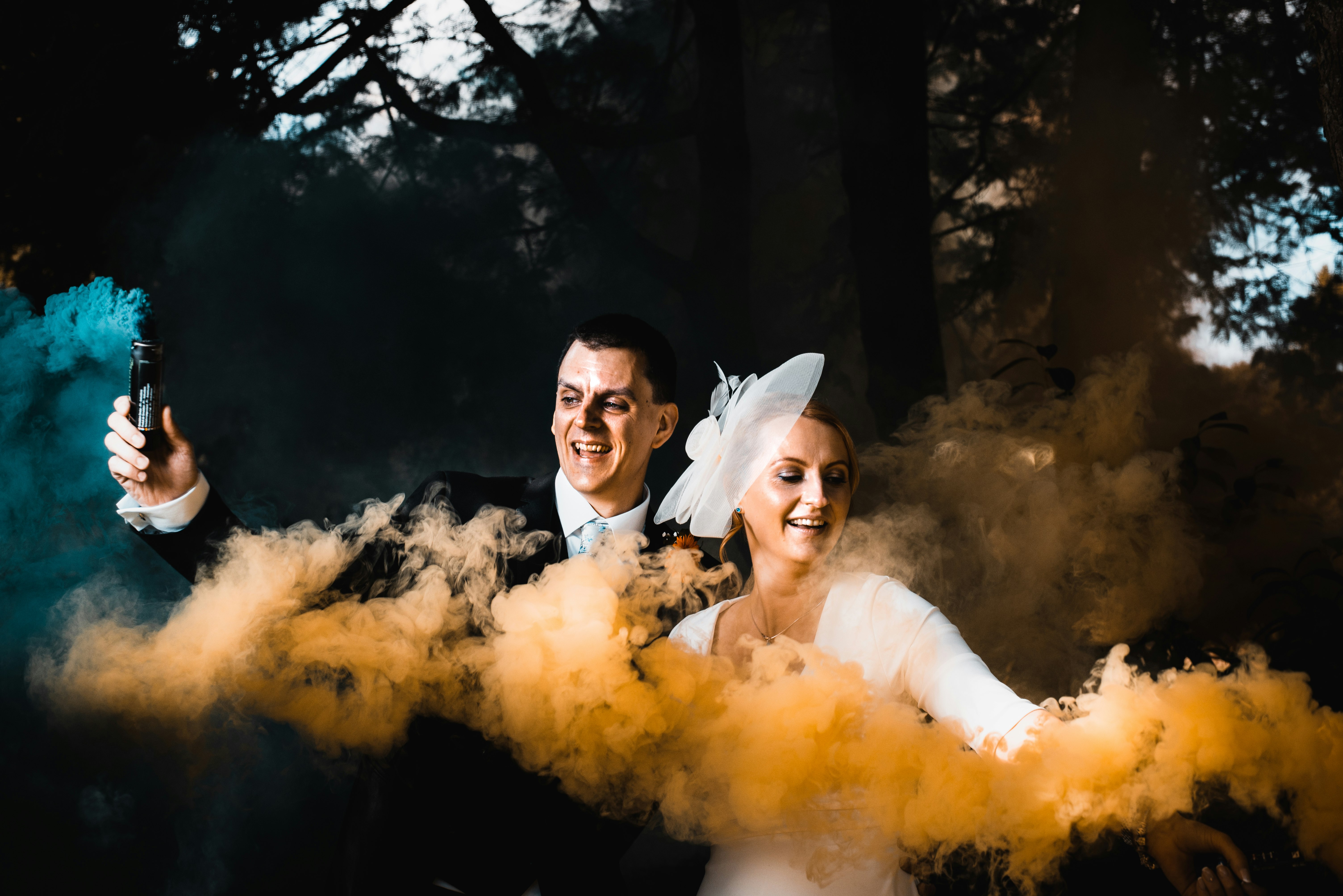 bride and groom holding smoke bottles